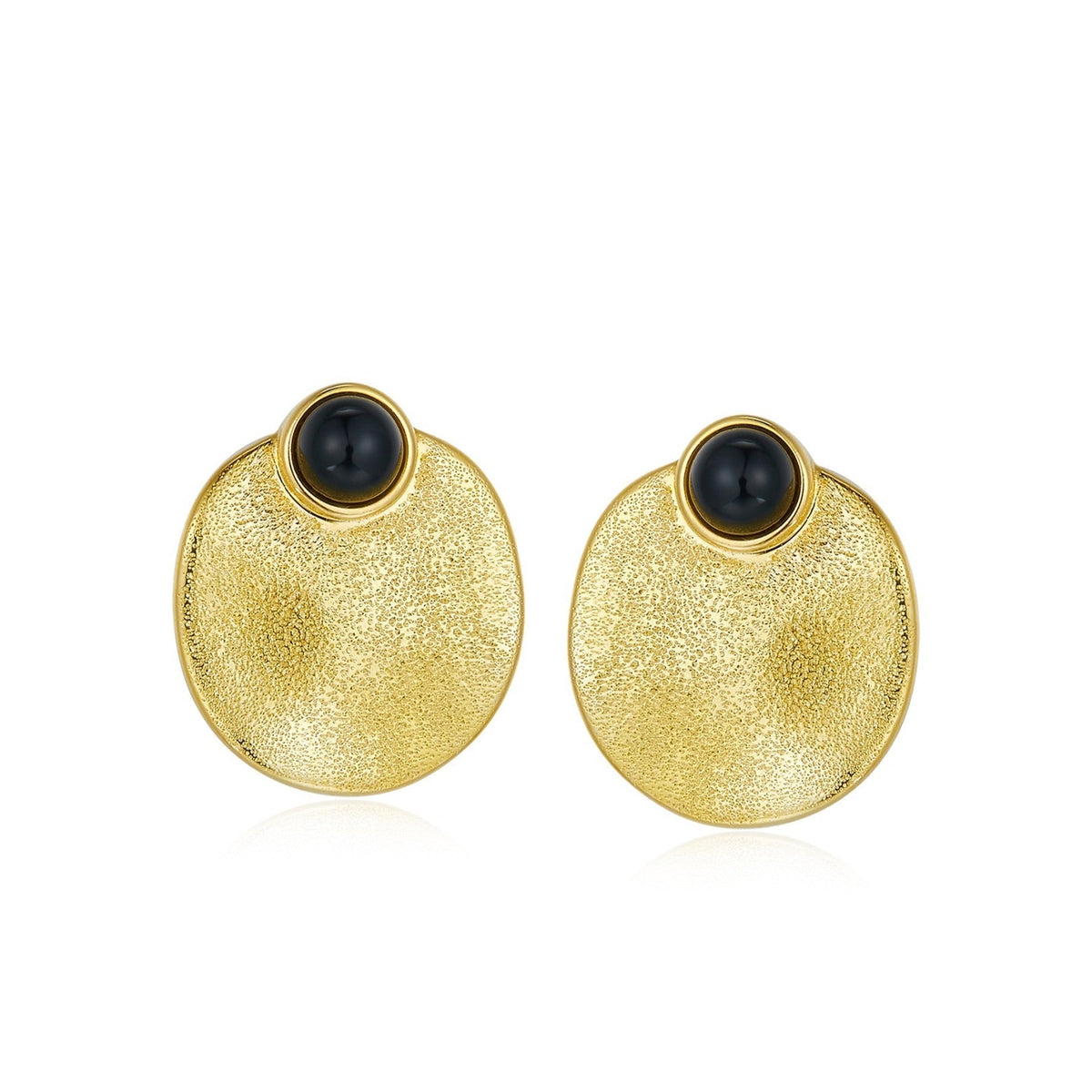 Pair of Awakened Time Eclipse stud earrings featuring polished round black onyx cabochons set atop textured dished gold circular discs on a white background.