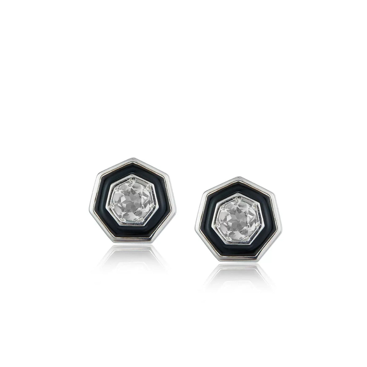 Pair of Awakened Time hexagonal stud earrings featuring clear faceted crystal centers enclosed by black enamel halos and silver borders on a white background.