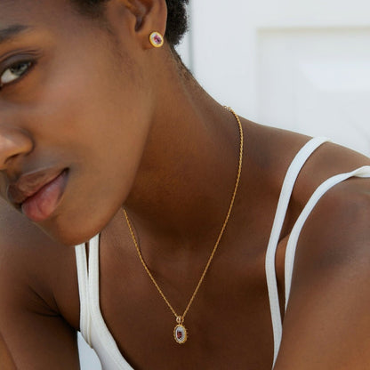 Model showcasing the Awakened Time Imperial Romance garnet stud earrings paired with a matching pendant necklace.