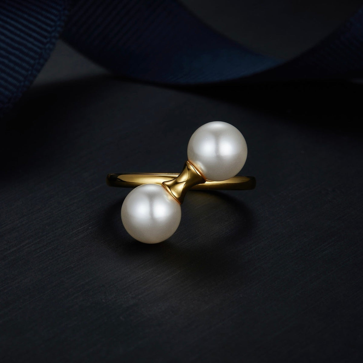 Angled studio view of The Petite Symétrie ring showcasing its balanced dual orbs and 18ct gold vermeil band by Awakened Time.