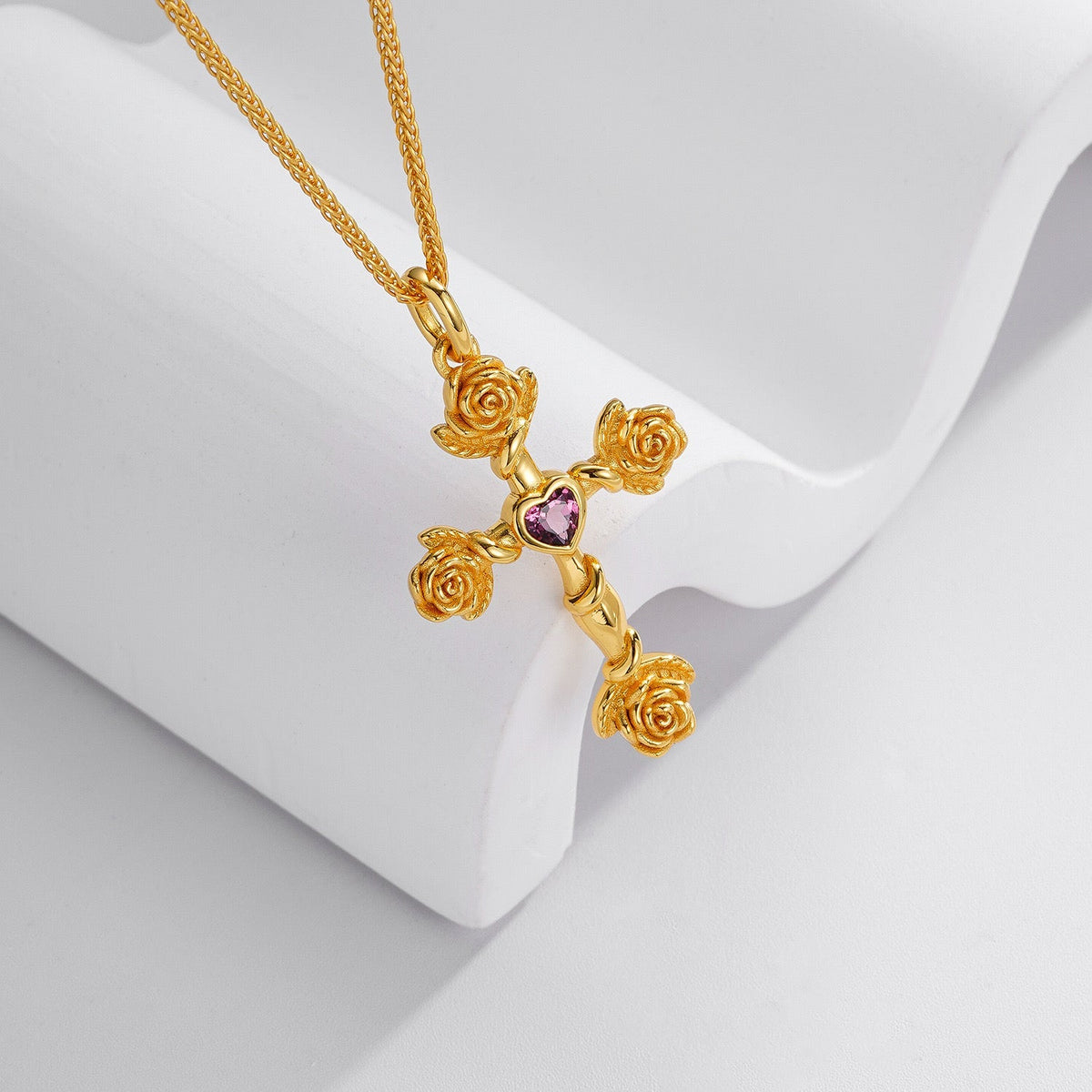 Close-up angled view of the Awakened Time Rosevine Cross Pendant on a white display stand.