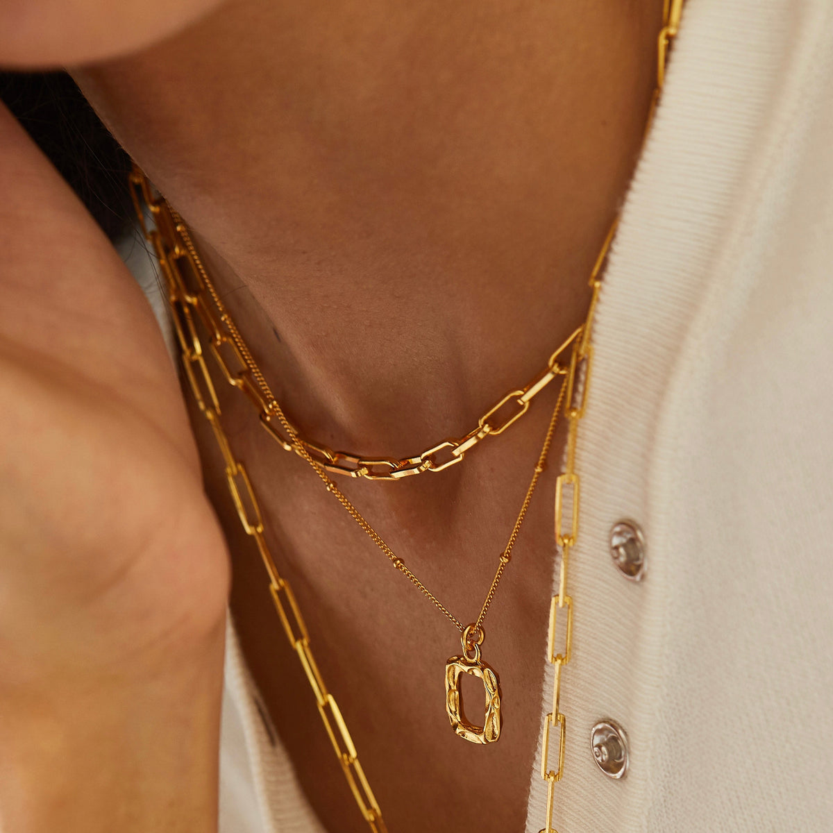 Gold paperclip necklace layered with fine gold necklaces